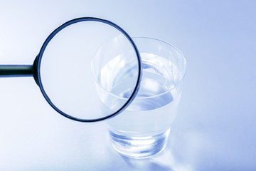 Testing or study composition of the water. Concept clean and control drink water. Cup with clean water on gray surface.