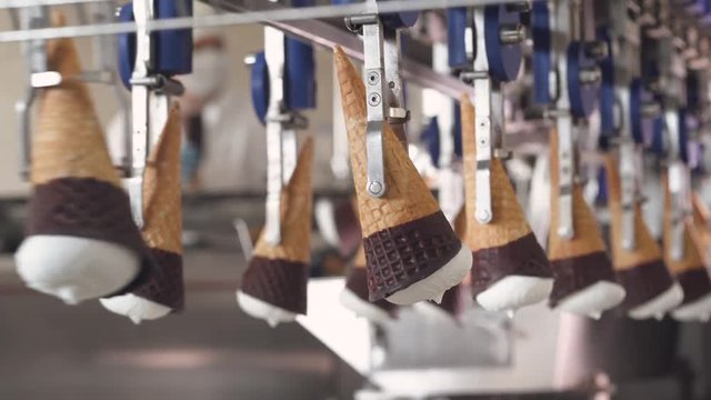 ice cream production, transportation waffle-cone with plombir ice cream on production line, dairy products.
