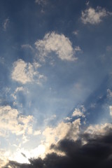 Fototapeta premium Raios solares entre nuvens no céu azul