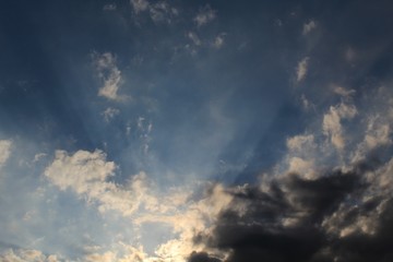 Raios solares entre nuvens no céu azul