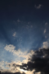 Raios solares entre nuvens no céu azul