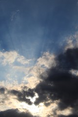 Naklejka na ściany i meble Raios solares entre nuvens no céu azul