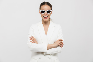 Beautiful happy woman posing isolated over white wall background wearing sunglasses.