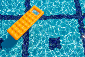 orange inflatable mattress in the pool