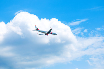 Commercial airplane landing at the airport with cloudy sky in the background