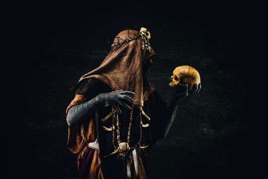 Portrait of a shaman holding a human skull in his hands
