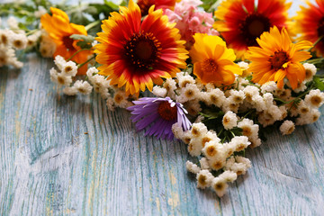 Fototapeta na wymiar bouquet of yellow, white and red flowers on wooden background, close up view