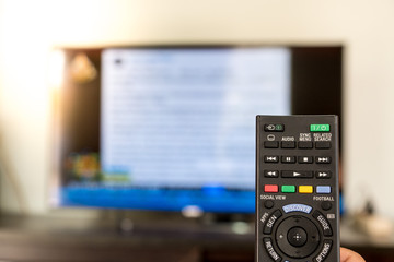 Fototapeta premium Black remote control. TV is blurred background