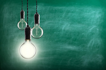 Idea and leadership concept -  bulbs on the grunge background