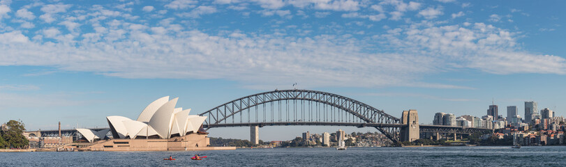 Kayakers paddling in Sydney harbour, with the famous Harbour Bridge and Opera House in the...