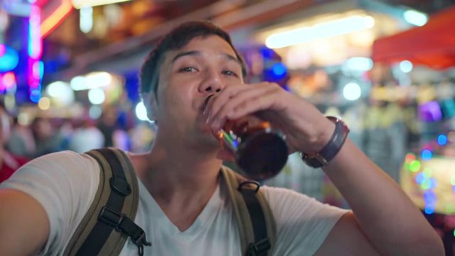 Traveler Asian blogger man travel in Bangkok, Thailand, male using mobile phone make vlog and live in social media while hangout at The Khao San Road. Men travel in Thailand concept.