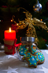 Decorated snowflake  handmade gingerbread cookies with red candle. Christmas traditional  background.