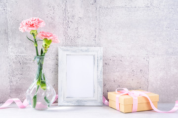 Close up, copy space, mock up, beautiful mothers day event concept handmade giftbox decoration photography, blooming fresh carnations with pink color ribbon isolated on gray wallpaper