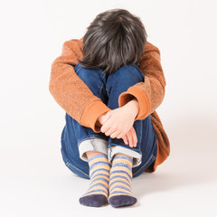 下を向いて悩む子供