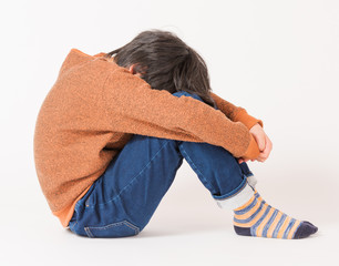 下を向いて悩む子供