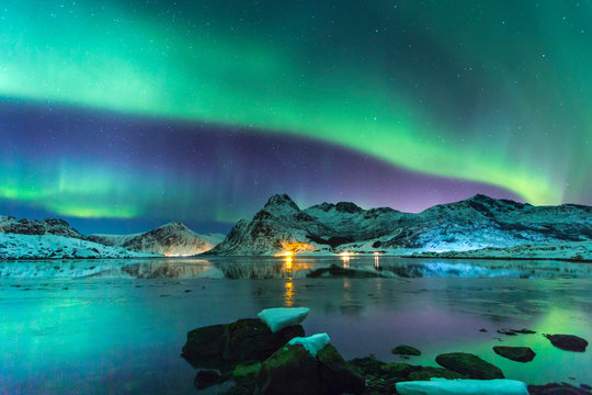Northern lights at night against the backdrop of beautiful mountains and glaciers