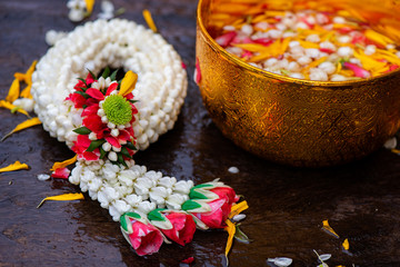 Rose jasmine leaves, golden water bowl, placed on green banana leaves Concept of the Songkran Festival Is an old tradition of Thailand