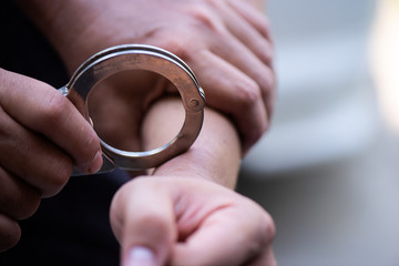 Man's hand is locked with the handcuffs