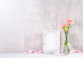 Close up, copy space, mock up, beautiful mothers day event concept handmade giftbox decoration photography, blooming fresh carnations with pink color ribbon isolated on gray wallpaper