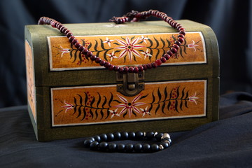 small chest with old school painted ornaments and beaded necklace