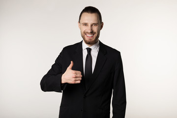 Smiling elegant businessman with beard in black suit and tie