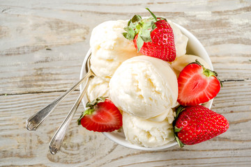 Homemade strawberry vanilla ice cream with fresh strawberries. Sweet berry summer dessert. Wooden background copy space