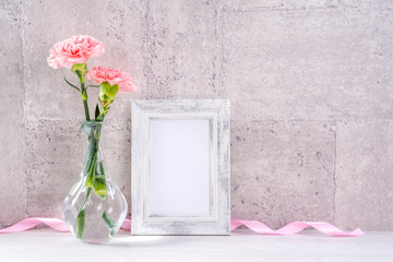 Close up, copy space, mock up, beautiful mothers day event concept handmade giftbox decoration photography, blooming fresh carnations with pink color ribbon isolated on gray wallpaper