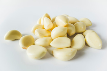 Peeled cloves of garlic close up on white color background