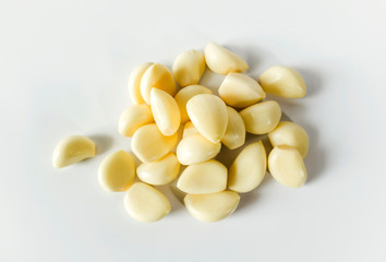 Peeled cloves of garlic on white color background