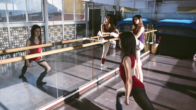 Young dancers training together in studio warming up and flexing in sunlight