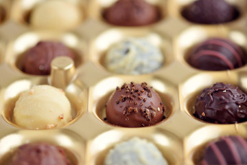 Assorted of chocolate candies in gold gift box. Selective focus
