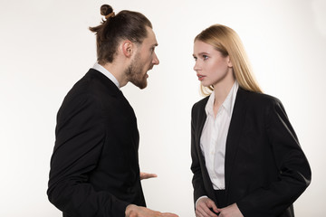 Attractive businessman with beard and trendy hairstyle in black suit screaming at his subordinate who can't cope the task