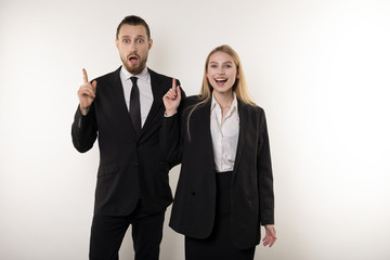 Two attractive business partners in black suits came up with an idea how to improve their business