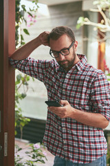 Fototapeta premium Modern man using cellphone outdoors.