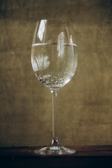 cropped glass of white wine on a rustic wooden brown background. rest, holiday, party. alcoholic drink closeup. copy space