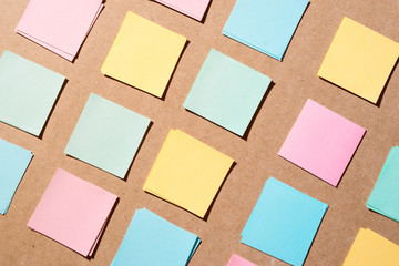 Multi colored notepads laying on a wooden plank board surface with copy space