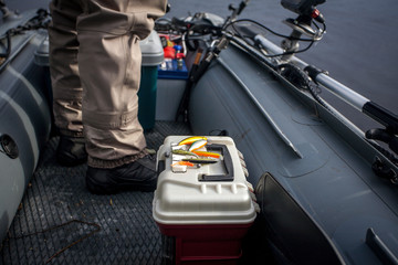 Fishing wobblers on the box inside the Inflatable boat during the freshwater fishing on the Lake. Closeup view