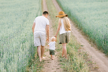 A young family have a fun with their little baby in the field