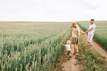 A young family have a fun with their little baby in the field