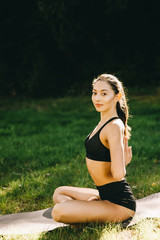 Fototapeta na wymiar Beautiful fitness girl exercising in nature on sunny summer day.