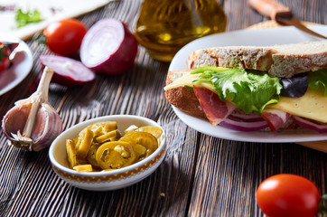 Sandwich with bacon, cheese, garlic, jalapeno pepper and herbs on a plate