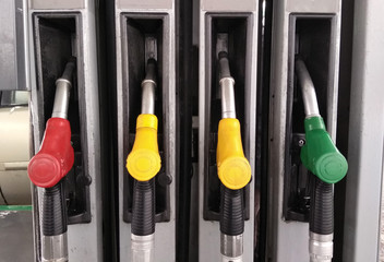 Colorful petrol pump filling nozzles. Gas station in a service. Multi color fuel pistols on fuel station. 