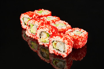 Classical roll sushi with shrimp, avocado and red caviar on black background for menu. Japanese food