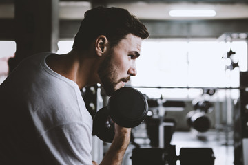 Closeup men healthy holding dumbbell workout and building body at gym fitness