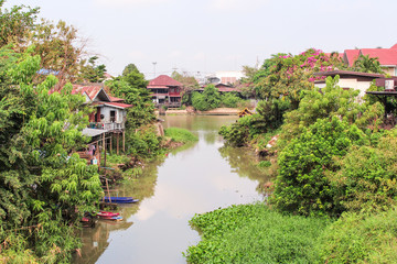 The image of old houses with boats in woods by Pasak River in Ayutthaya.