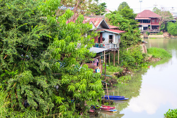 The image of old houses with boats in woods by Pasak River in Ayutthaya.