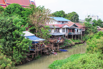 The image of old houses with boats in woods by Pasak River in Ayutthaya.