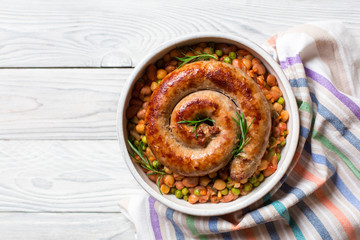 Italian sausage - salsiccia fresca, with bean stew and rosemary on a white background