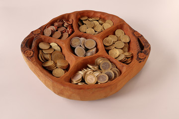 WOODEN TRAY THAT HAS MONEY COINS ORGANIZED INTO COMPARTMENTS