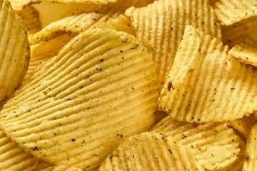 Background of juicy corrugated potato chips close-up